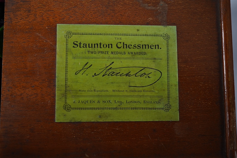 An early 20th century boxed J. Jaques & Son Staunton chess set, ebony and boxwood pieces, contained within the original velvet lined teak box with sliding lid and paper label to lid with facsimile of Howard Staunton sign